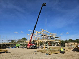 Glulam and Timber Frame structure being built with crane visible