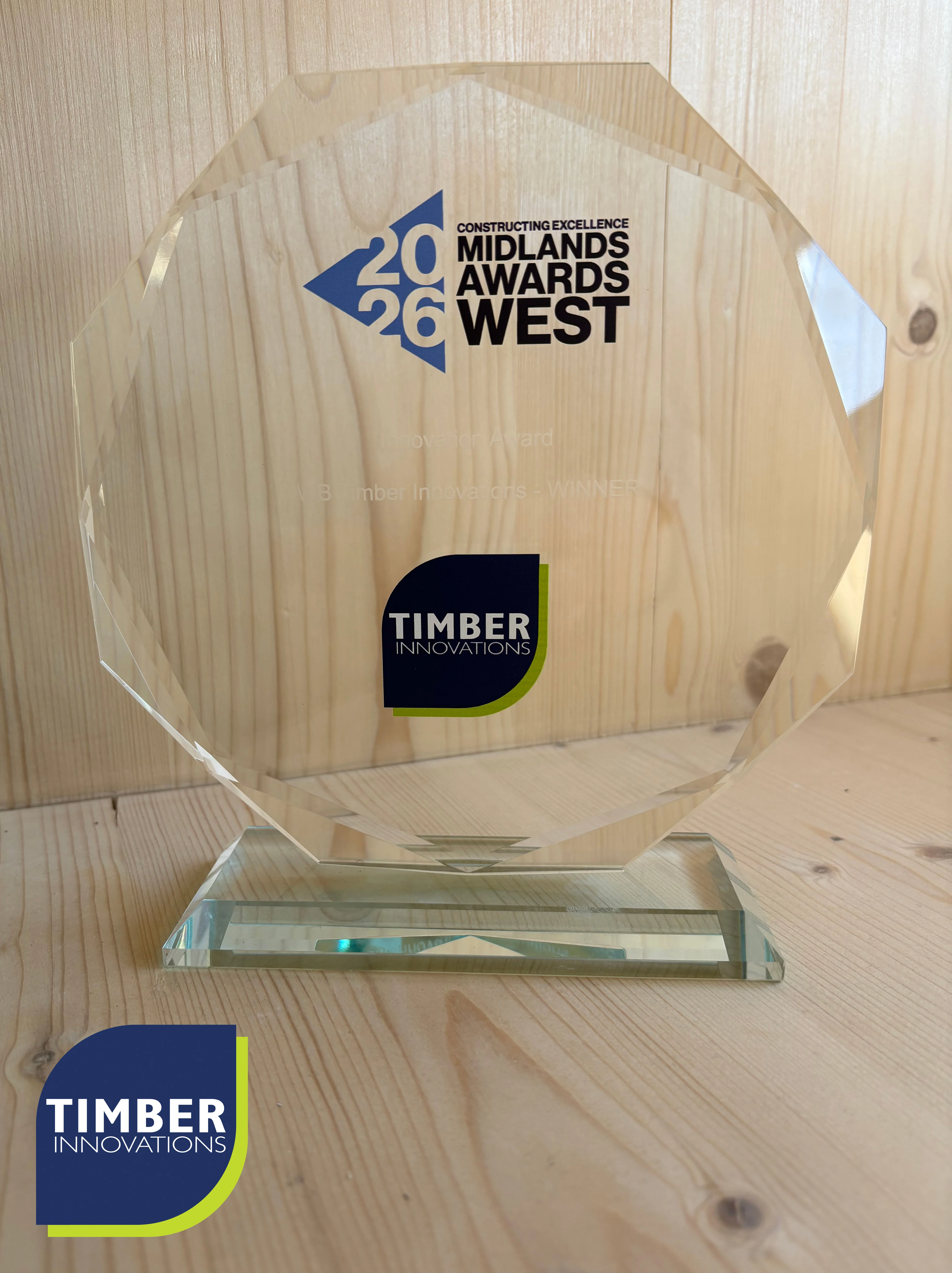 TI News 2 Circular glass award sat on timber